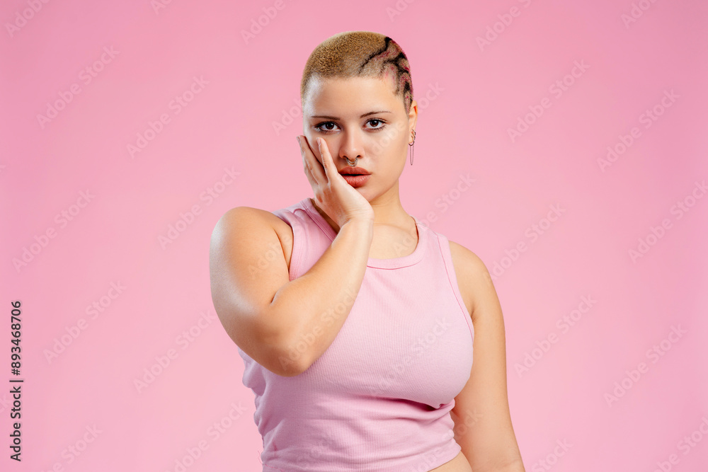 Young queer woman with shaved head posing in studio Young queer woman with shaved head posing in studio