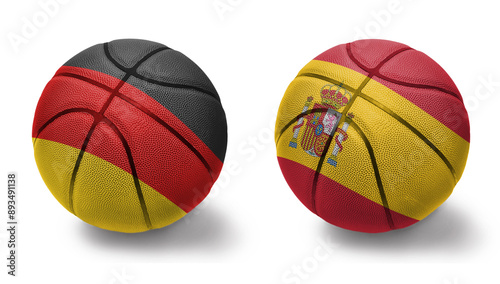 basketball balls with the national flags of spain and germany on the white background. photo