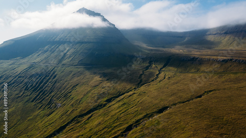 Funningur village, Faroe Islands. Sunny day in summer. Amazing nature in Faroe Islands. Eysturoy Island. Gonguturur or Hvithamar Trailhead. Faroese fjord and summits