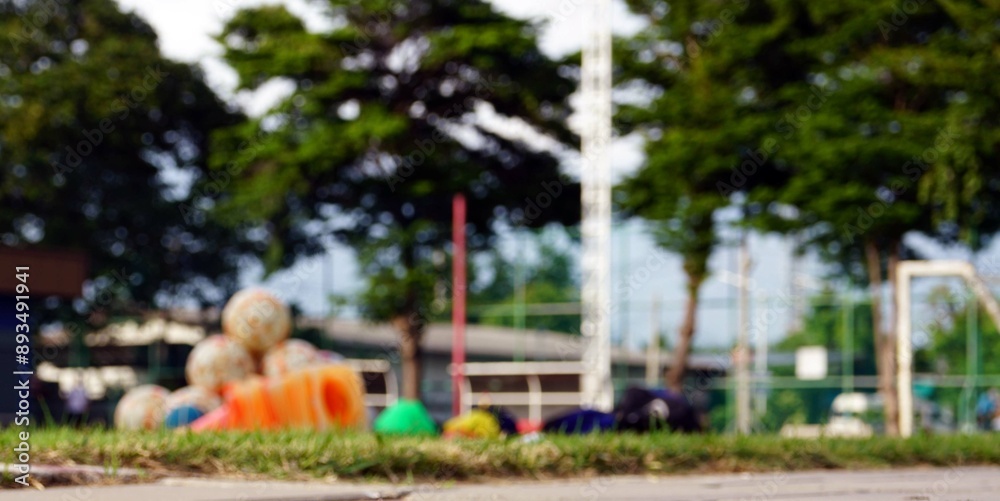 A blurred view of a lot of football and equipments on the grass in a field. A blurred view of a lot of football and equipments on the grass in a field.