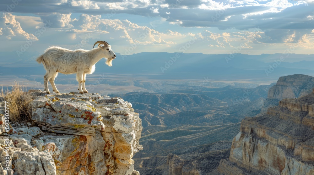 Naklejka premium Mountain goat standing on a rocky cliff with a scenic background