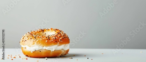 Delicious freshly baked bagel with cream cheese on a minimalist background. Perfect for breakfast-themed stock photos. photo