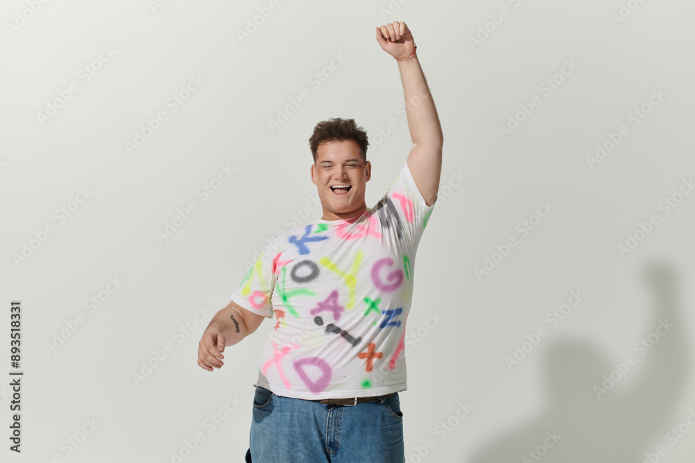 Man in a white shirt with colorful patterns, raising their fist with joy Man in a white shirt with colorful patterns, raising their fist with joy