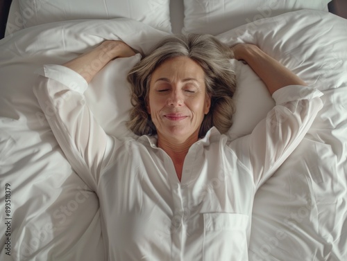 A person resting on a bed with their eyes shut, possibly waking up or recovering from something photo