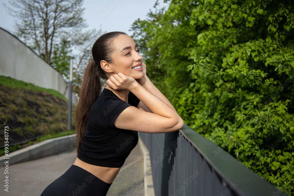 Fit woman wearing sportswear posing outdoor during her morning workout Fit woman wearing sportswear posing outdoor during her morning workout