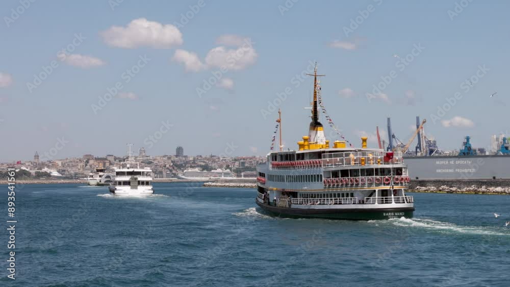 Two ferries travel through the waters of Istanbul Harbor on a sunny day, with a city skyline in the background. Two ferries travel through the waters of Istanbul Harbor on a sunny day, with a city skyline in the background.