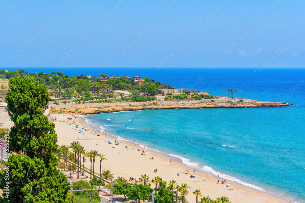 Sunny Tarragona Beach with Palm Trees and Clear Waters Sunny Tarragona Beach with Palm Trees and Clear Waters