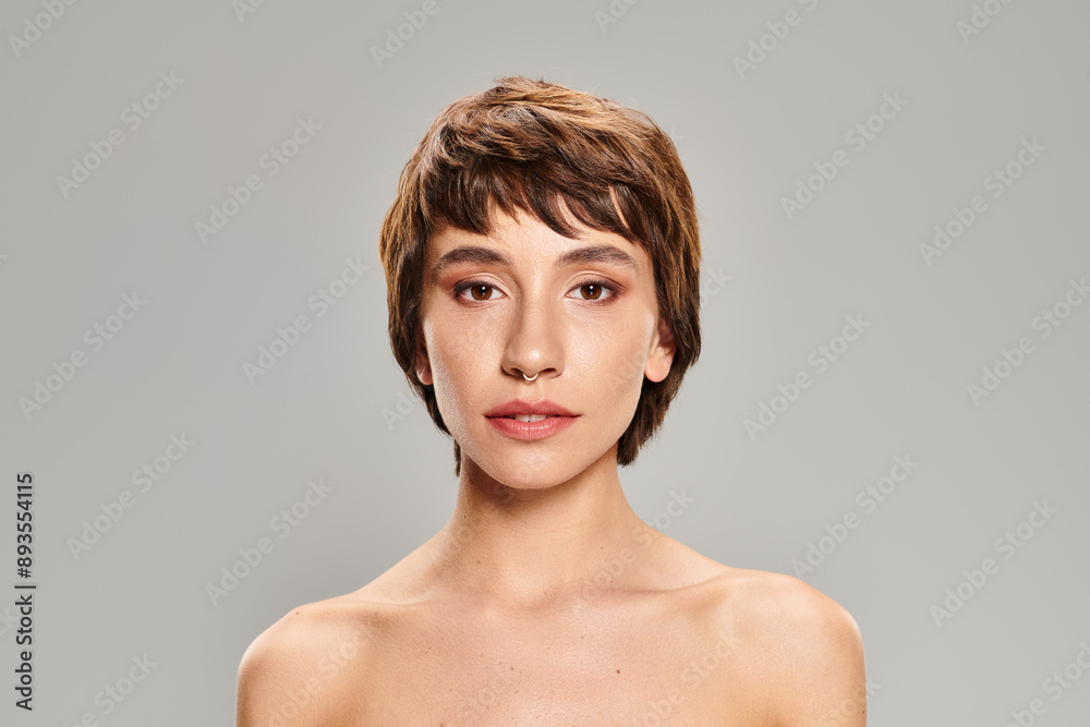 A close-up of a person with short hair posing on a vibrant backdrop. A close-up of a person with short hair posing on a vibrant backdrop.