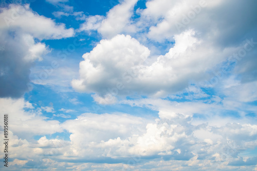 Cute background with fluffy cumulus clouds. Blue summer sky.
