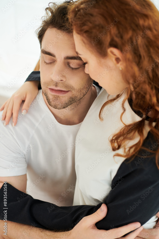 A man and a woman tenderly embrace each other in a cozy bedroom, sharing a moment of love and connection. A man and a woman tenderly embrace each other in a cozy bedroom, sharing a moment of love and connection.