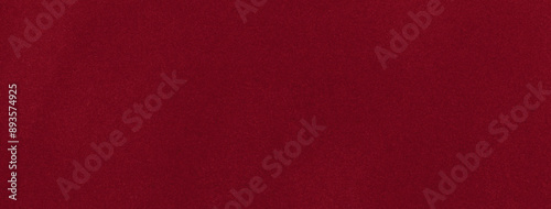 Dark red matte background of suede fabric, closeup. Velvet texture of wine seamless textile, macro.