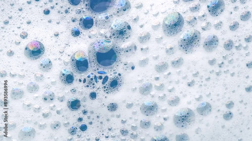 Foam background. Liquid soap popping bubbles, Froth bubbles backdrop. Soap foam structure over blue. Soap sud macro, close-up. Clean, cleaning, washing, laundry. Top view. Foam background. Liquid soap popping bubbles, Froth bubbles backdrop. Soap foam structure over blue. Soap sud macro, close-up. Clean, cleaning, washing, laundry. Top view.
