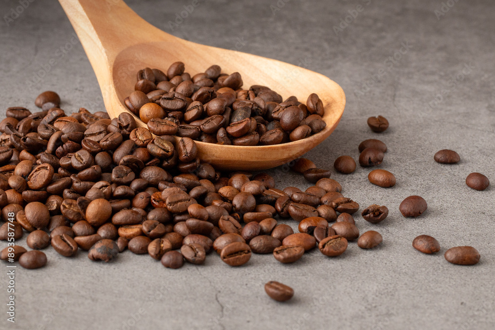 Mountain of coffee beans with wooden spoon to collect them Mountain of coffee beans with wooden spoon to collect them