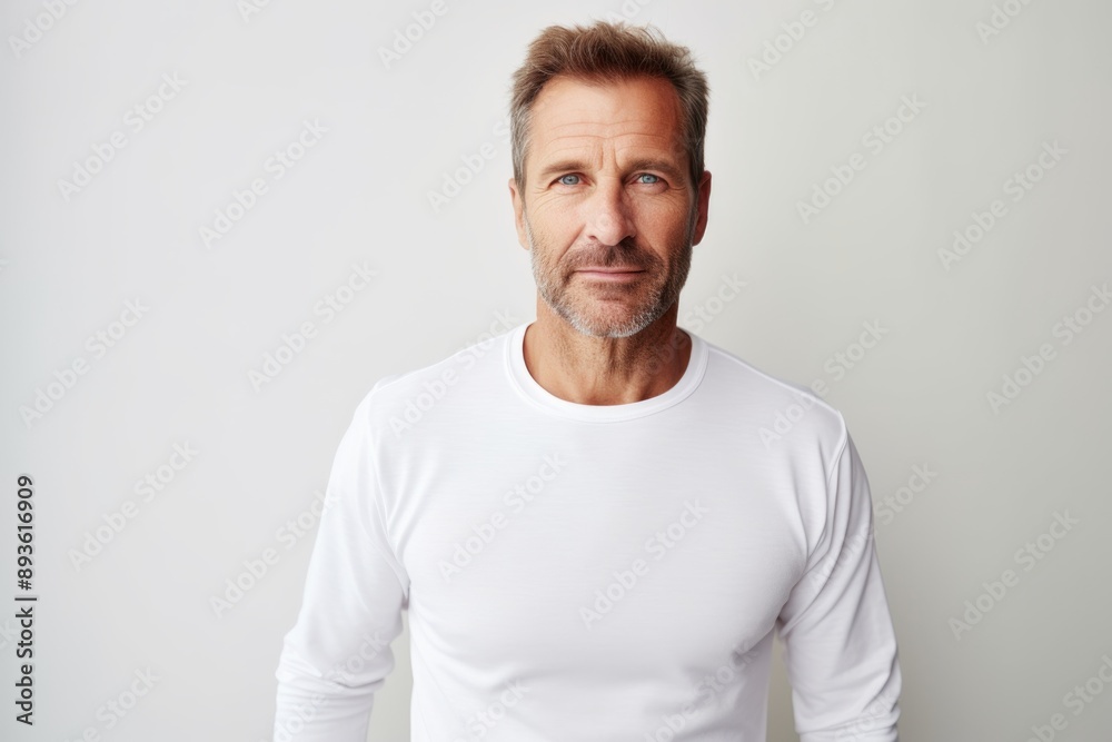 Portrait of a content man in his 40s sporting a long-sleeved thermal undershirt on white background Portrait of a content man in his 40s sporting a long-sleeved thermal undershirt on white background