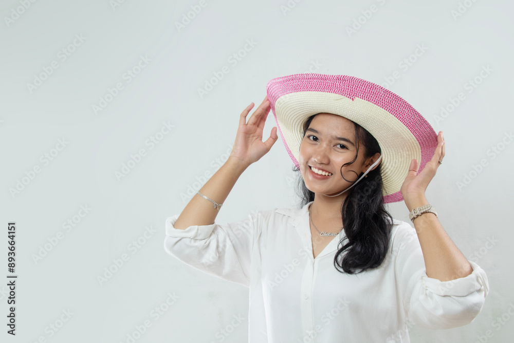 Young beautiful elegant Asian woman wearing summer hat while smiling isolated on white background. Young beautiful elegant Asian woman wearing summer hat while smiling isolated on white background.