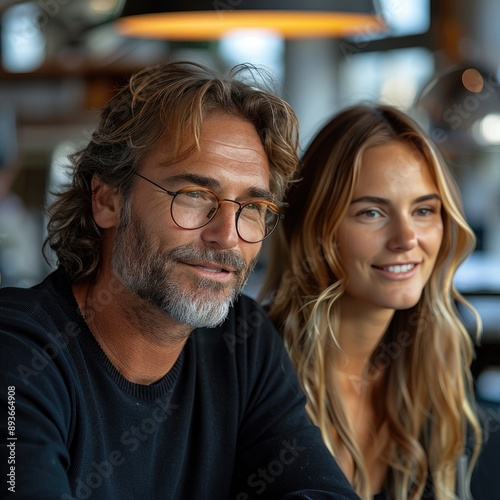 Smiling couple enjoying a relaxed moment in a cozy cafe, sharing a warm and joyful atmosphere together.