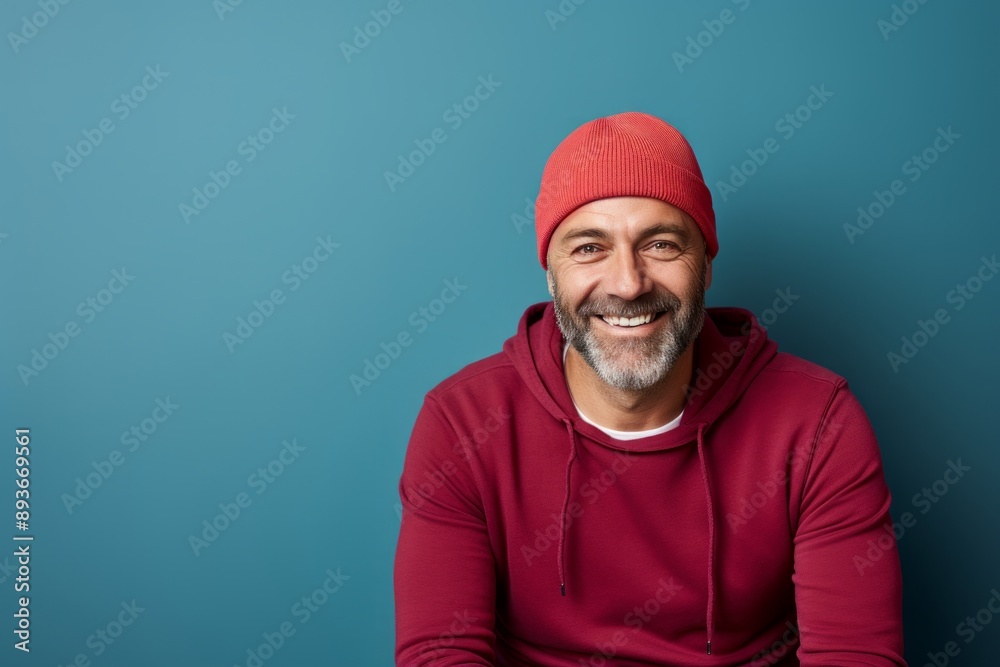 Portrait of a cheerful man in his 40s sporting a trendy beanie while standing against modern minimalist interior Portrait of a cheerful man in his 40s sporting a trendy beanie while standing against modern minimalist interior