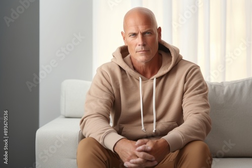 Portrait of a content man in his 50s sporting a comfortable hoodie in modern minimalist interior