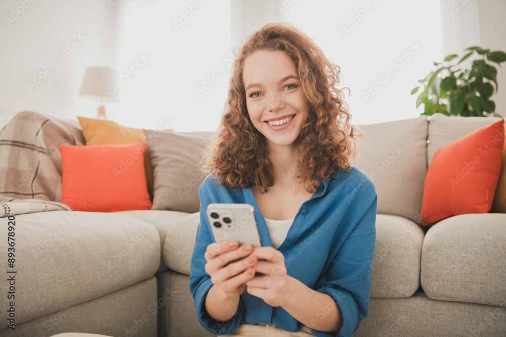 Photo of attractive trendy young woman sit floor hold device blue shirt move new apartment home interior indoors Photo of attractive trendy young woman sit floor hold device blue shirt move new apartment home interior indoors