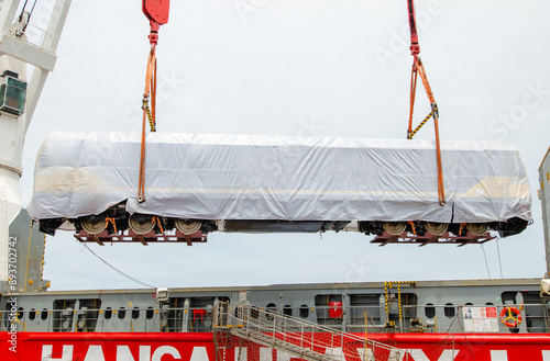 Unloading operation of project  cargo with port heavy lift cranes A crane on a large cargo ship docks loading a diesel-electric locomotive.  at Laem Chabang Port photo