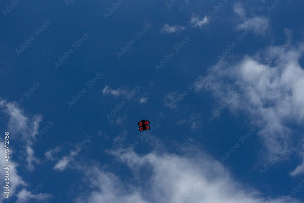 small drone flies against the blue sky, view from below, copy space small drone flies against the blue sky, view from below, copy space