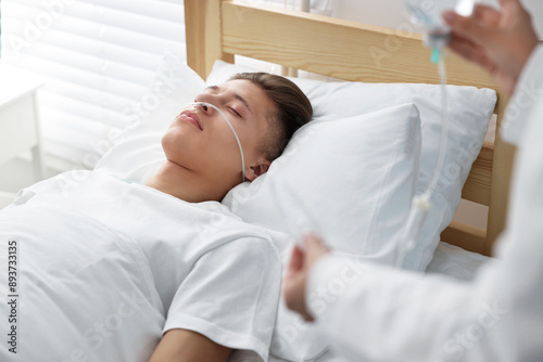 Coma patient. Doctor near unconscious young man in hospital, closeup