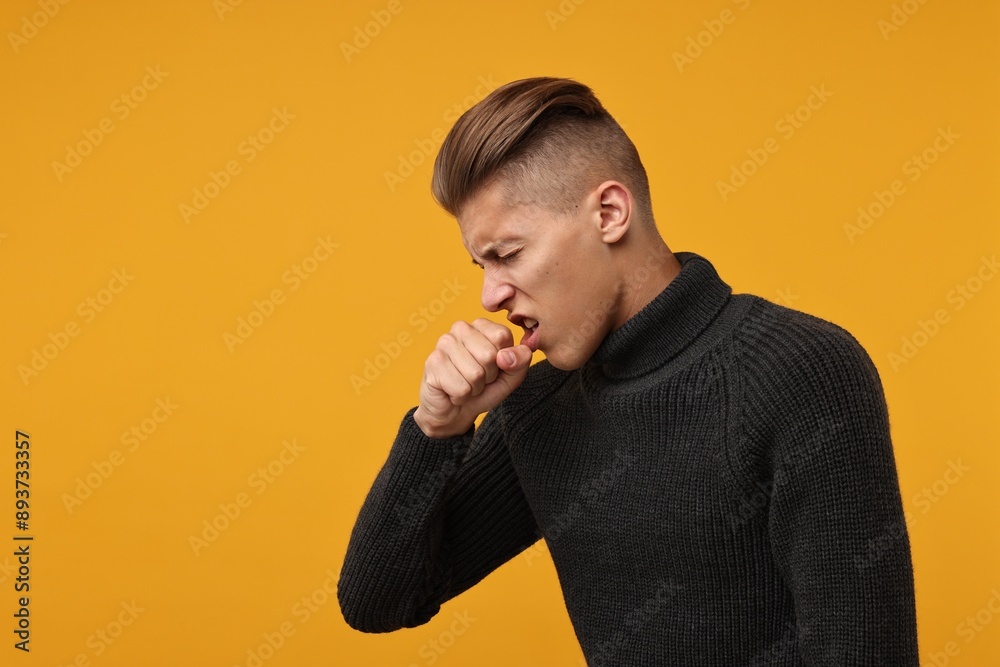 Sick man coughing on orange background, space for text. Cold symptoms Sick man coughing on orange background, space for text. Cold symptoms