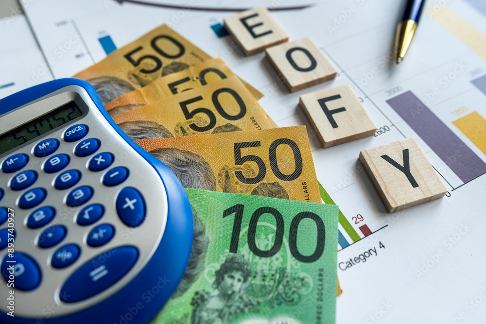 Financial businessman analyze the graph, aud australian dollar pen calculator, wooden cubes EOFY Financial businessman analyze the graph, aud australian dollar pen calculator, wooden cubes EOFY