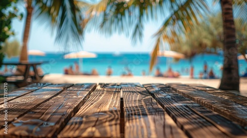Fototapeta Naklejka Na Ścianę i Meble -  A rustic wooden tabletop with a blurred view of a sunny beach in the background