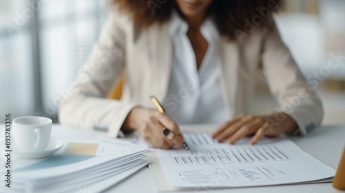 Top-down shot of professional woman approving a compliance report, high angle, deal documents on desk, close-up of hands reviewing the report.