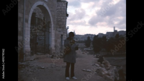 Jerusalem Street Food 1975 - A man wearing an Russian ushanka enjoys a sandwich as he walks in Jerusalem, in 1975. photo