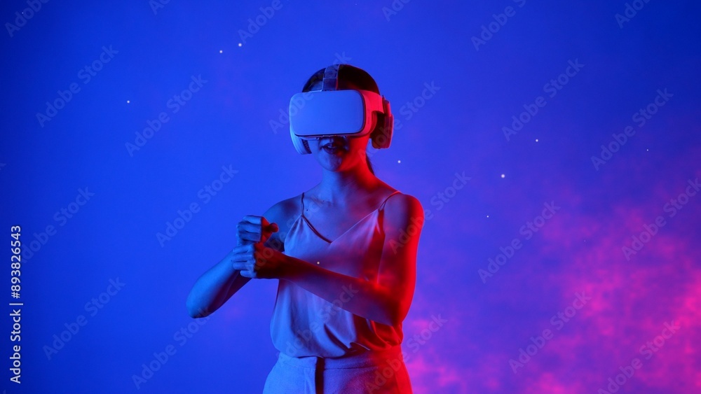 Fototapeta premium Woman player using VR transfer to fantastic metaverse fencing game box material neon by sword laser fantasy gaming space with lighting bokeh on blue smoke in meta 3D cyberspace world. Hallucination.