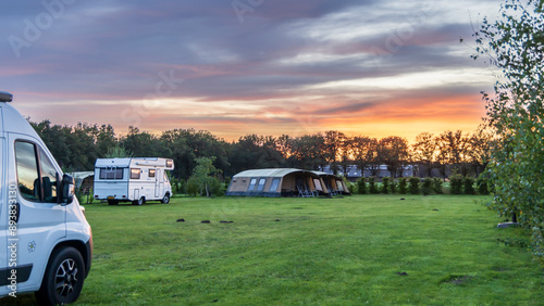 Bild auf Leinwand Panorama landscape with beautiful sunset at farm campsite with family tents and