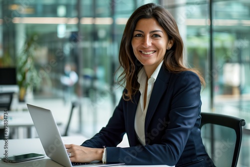 Professional Woman Working on Laptop in Modern Office Setting