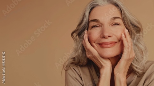 beauty portrait of a smiling woman 60 years old with gray hair on a neutral background, concept of natural female beauty and skin care, copy space