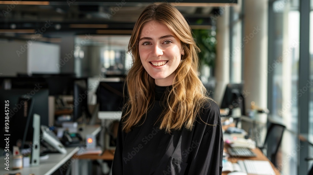 Corporate professional with a friendly smile in an open-plan office Corporate professional with a friendly smile in an open-plan office
