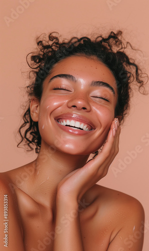 Woman smiling while touching her flawless glowy skin