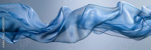 A piece of blue fabric drifts gracefully through the air, creating a soft, elegant curve