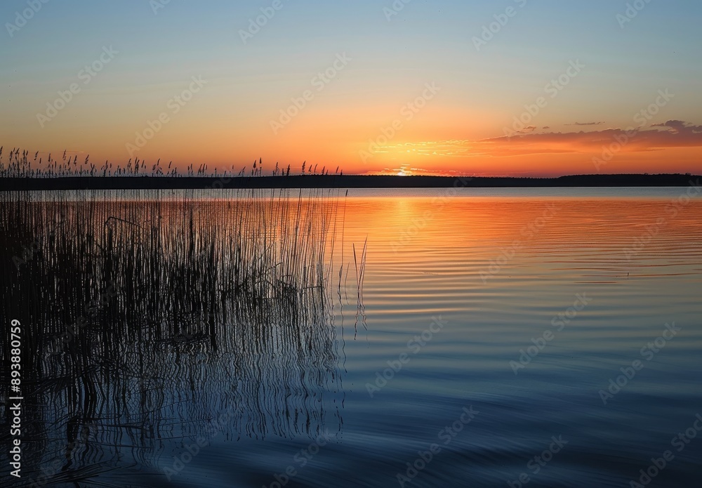 serene sunset over the Black Body. The lake reflects an orange and blue sky, with some clouds visible in the distance serene sunset over the Black Body. The lake reflects an orange and blue sky, with some clouds visible in the distance