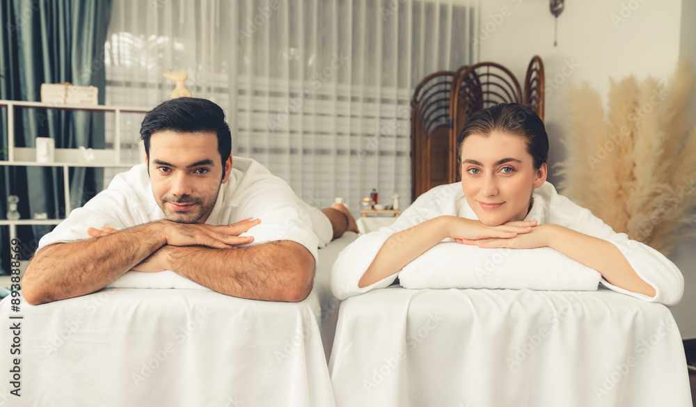 Fototapeta premium Caucasian couple customer enjoying relaxing anti-stress spa massage and pampering with beauty skin recreation leisure in day light ambient salon spa at luxury resort or hotel. Quiescent