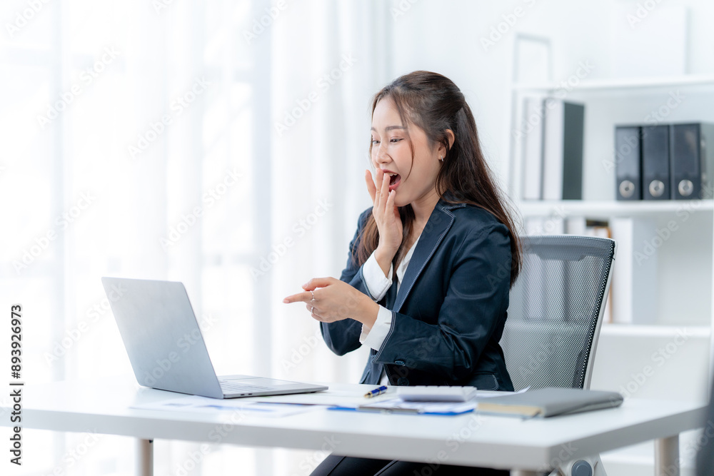 Asian business woman using computer looking at laptop and talking on video conference Asian business woman using computer looking at laptop and talking on video conference