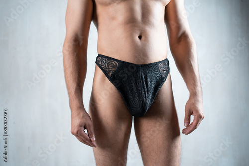 young handsome man in sexy transparent lace panties with mesh sheer textile, strong muscular buttocks, hot male in erotic underwear panty closeup