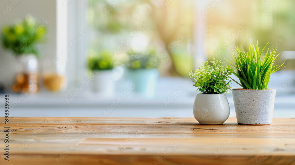 wooden kitchen desk with green plants in front of modern blurred white kitchen in background wooden kitchen desk with green plants in front of modern blurred white kitchen in background