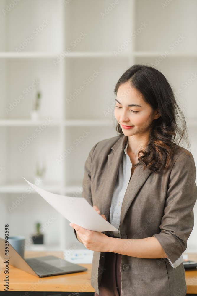 Asian businesswoman working with tiger skins notebooks graphs documents at modern desks using computers successful female e-commerce online