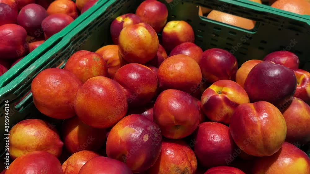 Ripe nectarines in a green crate at a market. Ripe nectarines in a green crate at a market.
