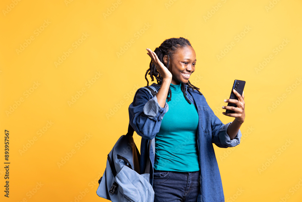 Smiling woman having friendly conversation with friends during teleconference meeting using smartphone, studio background. BIPOC person having fun catching up with mates during online videocall Smiling woman having friendly conversation with friends during teleconference meeting using smartphone, studio background. BIPOC person having fun catching up with mates during online videocall