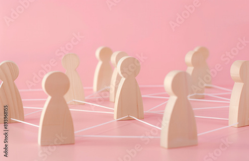 Wooden figures connected by lines, representing the concept of network and social interaction. People connecting in an office or business setting.