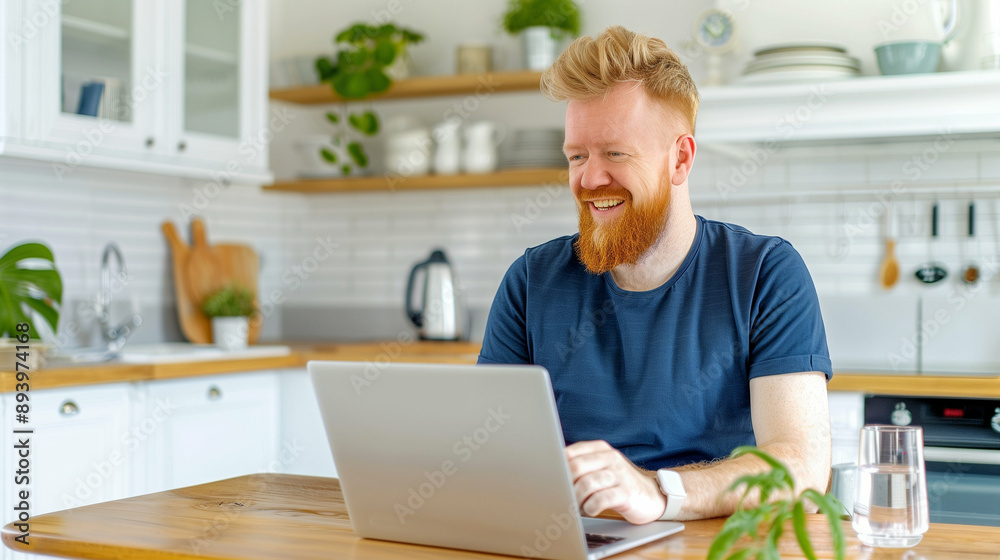 Laptop User Smiling While Working in Cozy Kitchen Environment. A Man Engaged in Productive Task at Home with Natural Light and Modern Decor Laptop User Smiling While Working in Cozy Kitchen Environment. A Man Engaged in Productive Task at Home with Natural Light and Modern Decor