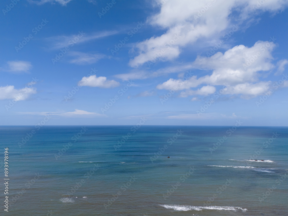 Blue ocean surface under sky with white clouds Blue ocean surface under sky with white clouds