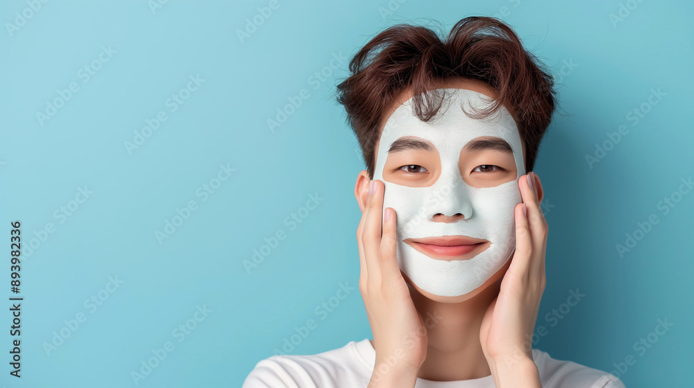 Man with moisturizing care mask on his face, background with space for text Man with moisturizing care mask on his face, background with space for text